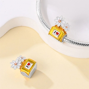 Detailed macro view of a daisy perfume bottle charm with I love perfume engraving