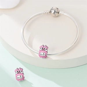 Detail of silver snake chain bracelet with pink enamel perfume bottle charms and bow