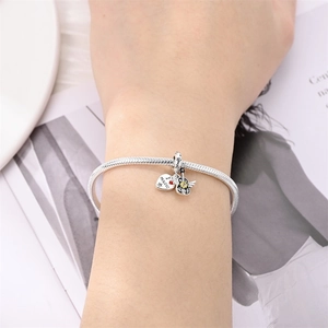 Bracelet à breloques guitare et cœur musical en argent porté sur un poignet