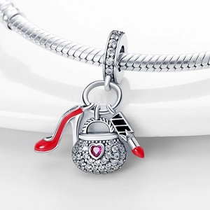 Macro detail of silver charm pendant with red heel, crystal handbag and lipstick charms