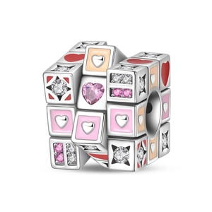 Vista macro de charm de cubo mágico plateado con corazones de esmalte y circonitas