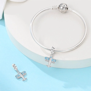 Detail of silver snake chain bracelet with blue enamel airplane charm and engraved clasp