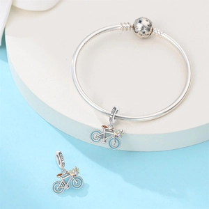 Detailed close-up of a silver bicycle charm and beads with 'We belong together' engraving