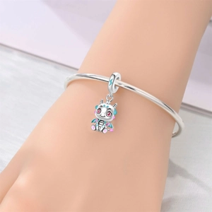 Detalle del amuleto de dragón de plata con esmalte de colores en un brazalete