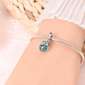 Luminous blue round charm with gold flakes and butterfly detail on silver snake chain