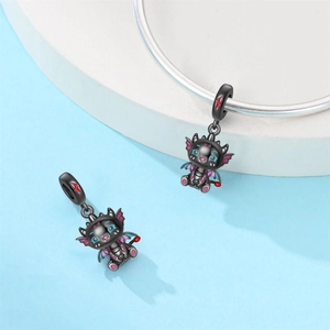 Detalle macro del charm de dragón negro con acentos de esmalte en pulsera de plata