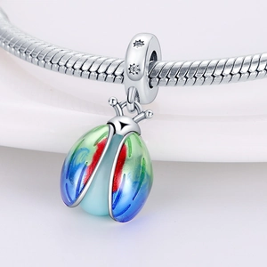 Macro shot of silver ladybug charm featuring a colorful gradient glow and star accents