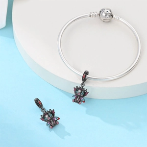 Detalle del cierre de pulsera de plata grabado con We belong together y dijes de dragón negro