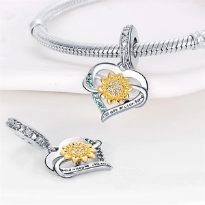 Close-up of sunflower heart charm with You are my sunshine engraving on silver snake chain