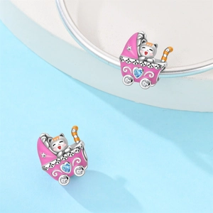 Detalle de abalorio de cochecito de bebé plateado con esmalte rosa, gato y gema de corazón azul