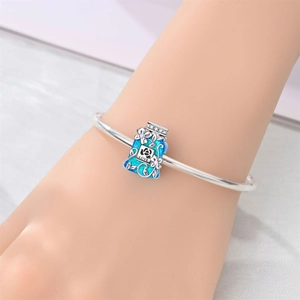 Detailed close-up of blue enamel bottle charm with LOVE engraving on silver bracelet