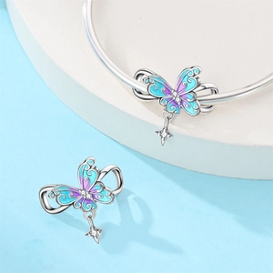 Detalle macro de dije de mariposa en esmalte azul violeta con colgante de estrella