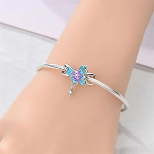 Detalle de brazalete de mariposa con esmalte azul degradado y colgante de estrella
