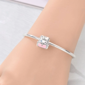 Close-up of silver school bag charm with Back to School engraving and pink enamel
