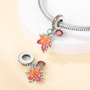 Detalle de dije de hoja de arce con esmalte naranja y circón en pulsera de cadena de serpiente