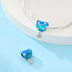Detail of silver heart balloon charm with blue enamel and 'Follow your heart' engraving