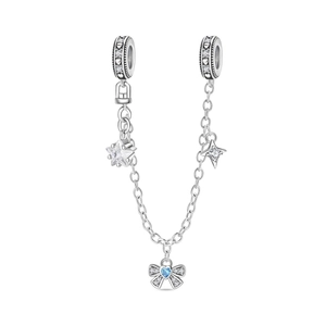 Detalle de cadena de seguridad en plata con circonita de corazón azul y mariposa
