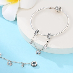 Detalle del cierre de pulsera de plata grabado con We belong together y dijes