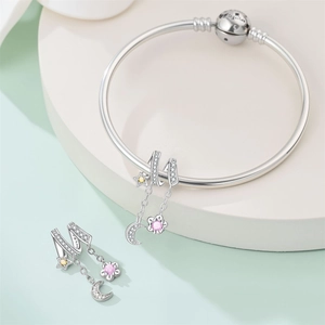 Vista detallada de pulsera de plata con colgantes de luna creciente y estrella