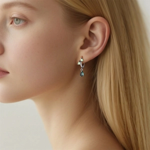 Elegant silver-plated drop earrings featuring green lily of the valley and blue pear-cut stone