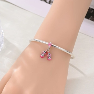 Pulsera de plata con colgante de zapatillas de ballet en esmalte rosa en la muñeca