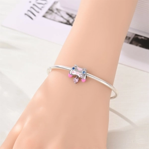 Detalle de dije de mando de juegos en plata con esmalte rosa y cristal de corazón púrpura