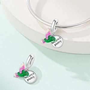 Detalle de dije de colibrí de plata con grabado de naturaleza para pulseras de joyas