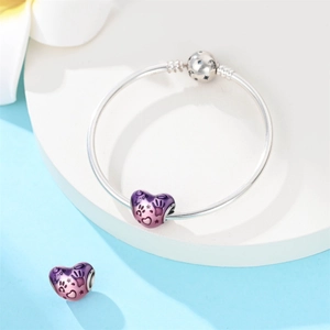 Dettaglio di bracciale snake in argento con ciondolo a cuore e smalto sfumato rosa viola