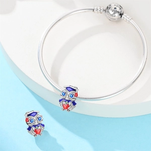 Detailed view of silver owl graduation charm with mortarboard cap on beaded bracelet