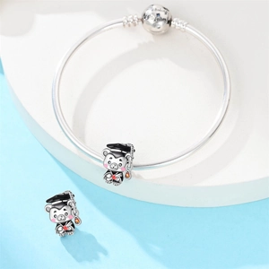 Detailed view of silver charm bracelet with graduation owl pendant and engraved buckle
