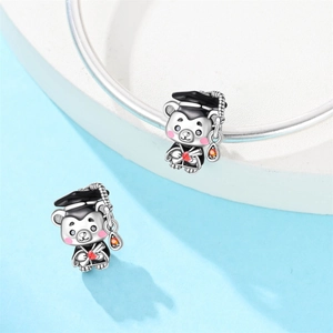 Detail of graduation bear charms in 925 silver with doctoral caps and red zircon hearts
