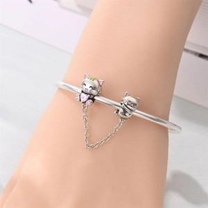 Dettaglio bracciale in argento con ciondoli a gatto, pietra cuore rosa e catenella