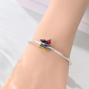 Detailed view of silver charm bracelet featuring academic motifs like books and a mortarboard