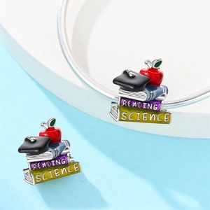 Macro detail of silver owl charm bead with books and graduation cap for DIY jewelry