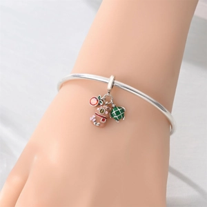 Dettaglio bracciale in argento con ciondoli smaltati a tartaruga, frutta e animali al polso