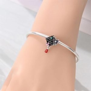 Detail of silver bracelet with a black graduation cap charm and Happy Graduates text