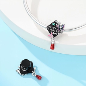 Macro view of silver owl graduation cap charm with Happy Graduates text and tassel