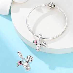Dettaglio del charm orsetto in argento con tulipano rosa e ciondolo con incisione