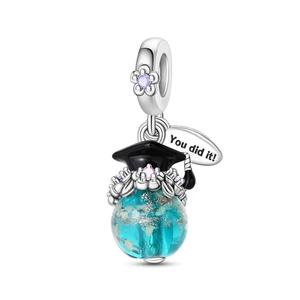 Macro shot of silver owl charm with blue bead and 'You did it!' engraved tag