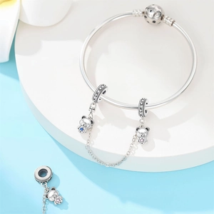 Dettaglio del bracciale con ciondoli a orsetto in argento e catena di sicurezza