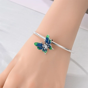 Dettaglio del bracciale argentato con farfalla in smalto blu-verde e piccoli cristalli