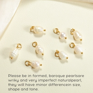 Set of seven natural baroque pearl charms with golden hoops on a soft leather surface