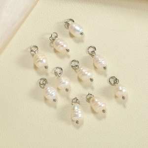 Macro shot of 10 baroque freshwater pearl pendants with silver metal hooks for jewelry DIY