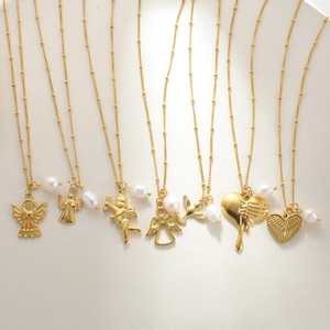 Detailed view of 18K gold plated angel wing pendants with natural freshwater pearls