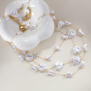 Collar dorado con perlas de agua dulce y dijes de corazón y luna en bandeja