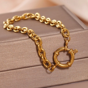 Détail d'un bracelet gourmette plaqué or 18 carats avec un grand fermoir rond à ressort