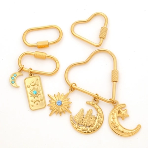 Golden geometric heart and oval carabiner lock connectors with celestial pendants set