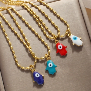 Macro shot of colorful Hamsa Hand necklaces with evil eye pendants on a jewelry tray