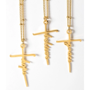 Détail de colliers croix dorés avec pendentifs Hope Believe et Grace sur chaînes à perles