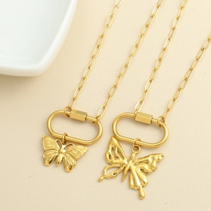 Detail of gold butterfly pendants on paperclip chain necklaces with lobster clasp